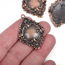  Copper charms with Victorian floral design held in a person's hand, showing slight convexity and details of the floral patterns.