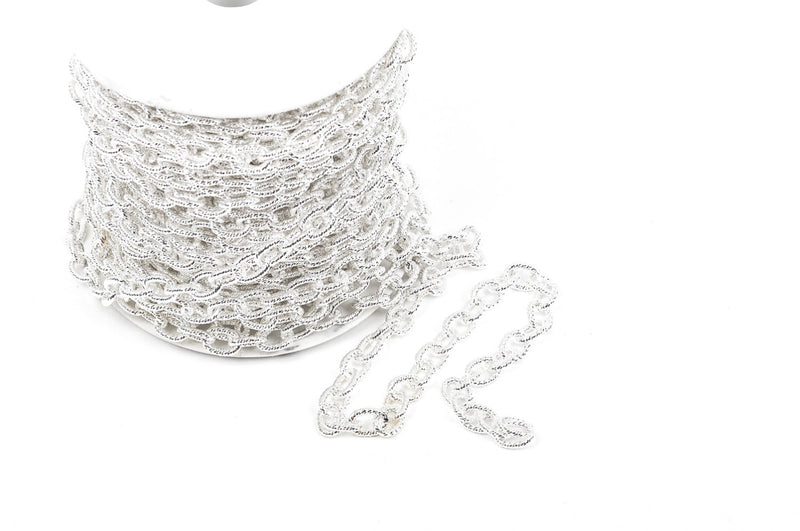 A spool of silver textured chain on a white background